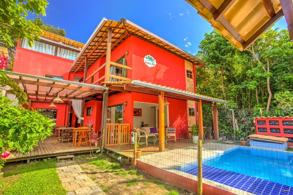 Exterior do i9 Embaú Flats & Suítes. A casa possui dois andares com paredes vermelhas, um jardim, restaurante e piscina.