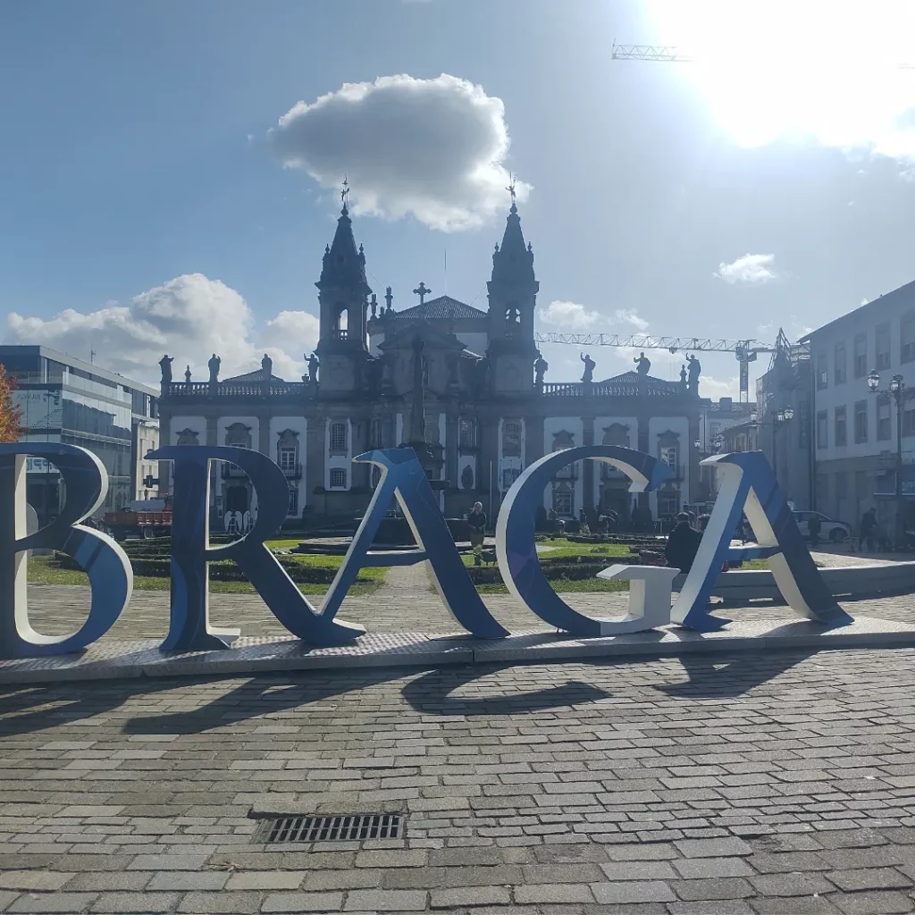 Letreiro escrito Braga a frente ao fundo uma propriedade. durante o dia.