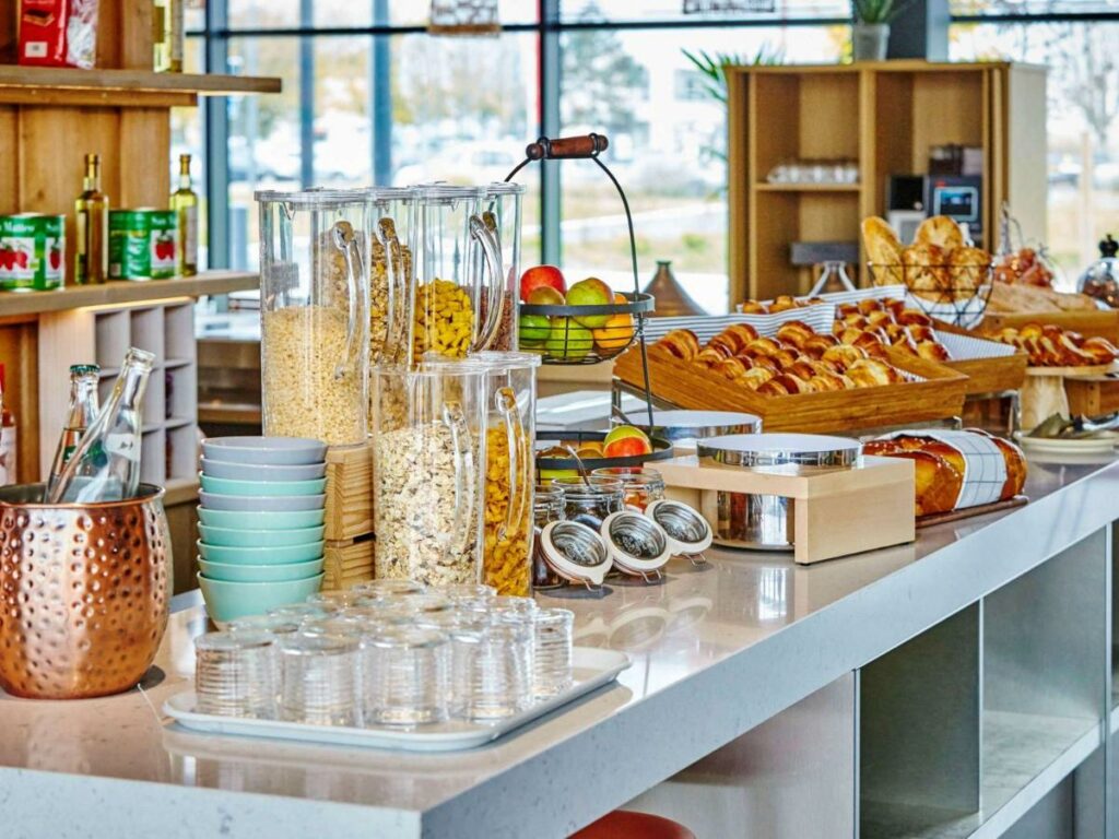 Itens de café da manhã e utensílios de cozinha em cima de uma bancada do Mercure Paris Orly Airport.