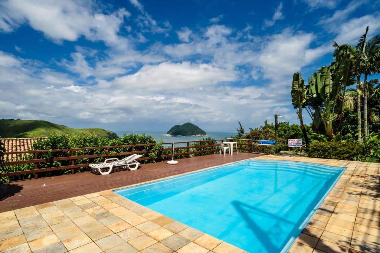 Vista da piscina do Loft com vista ao mar durante o dia com piscina ao centro com vista para o mar ao fundo. Representa airbnb em Toque-Toque Grande.