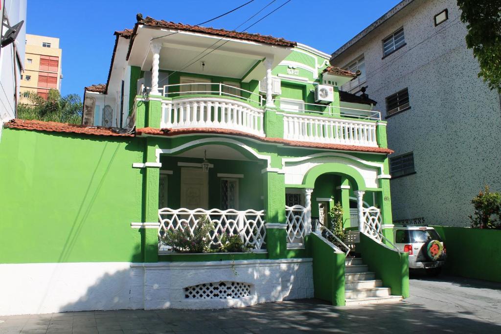 Fachada da Pousada Beira Mar. Uma escadaria na frente, e um sobrado. Do lado direito um carro estacionado.
