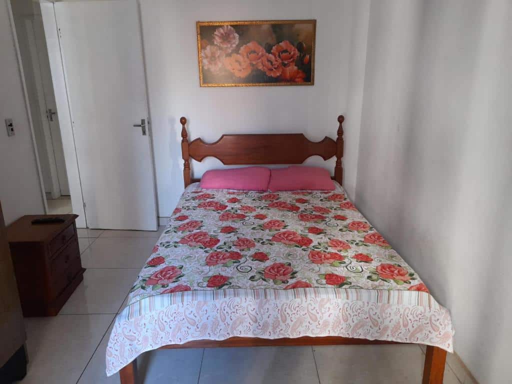 Quarto da casa PRAIA DO FORTE 3 MIN A PÉ. A cama de casal está no lado direito do quarto e no lado esquerdo há uma pequena cômoda com gavetas e uma porta. Imagem para ilustrar o post airbnb em Cabo Frio.