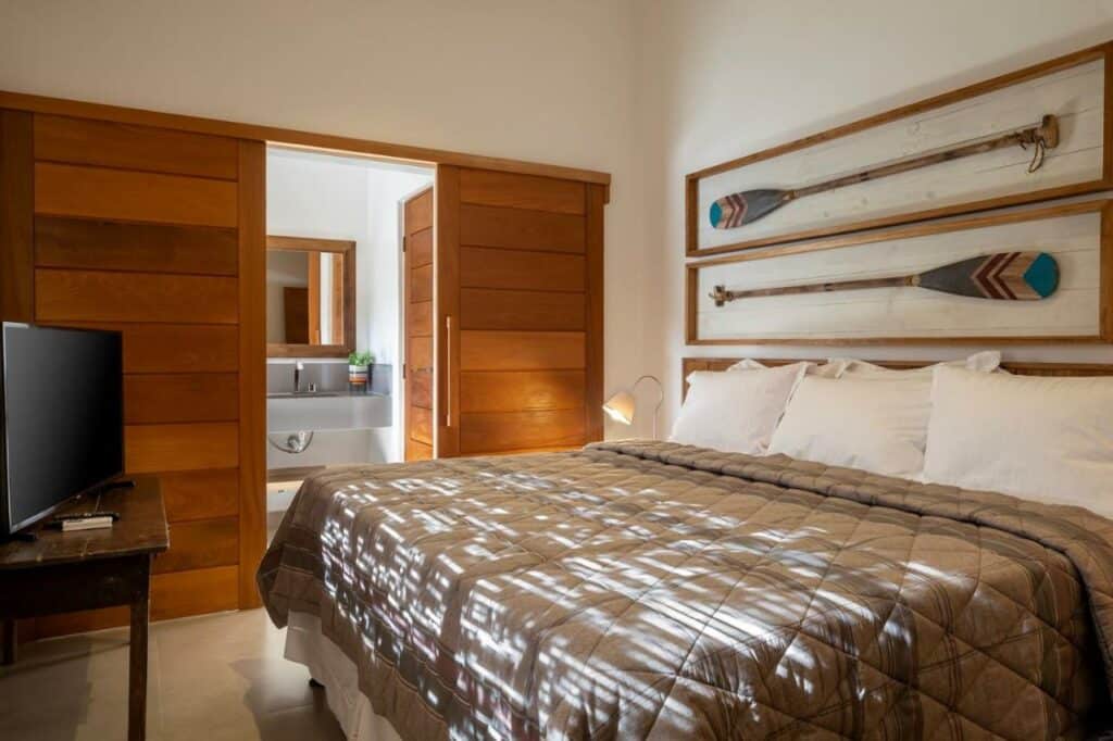 Quarto do Flamboyant Residence Quadrado com cama de casal do lado direito da imagem em frente a cama uma cômoda com TV e do lado esquerdo da cama um guarda-roupa.