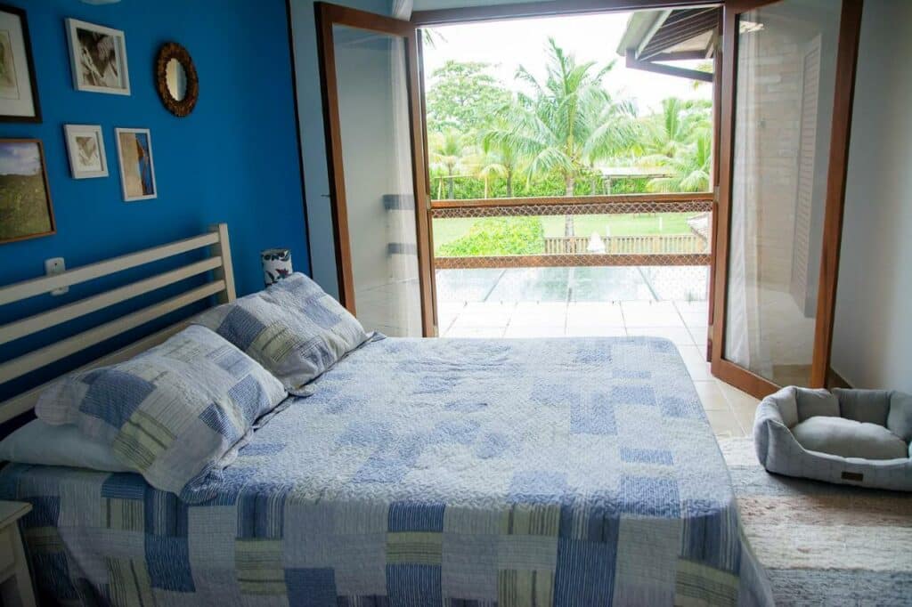 Quarto da Incrível casa pé na areia com Wi-Fi em Guaeca-SP com cama de casal da imagem o lado esquerdo da imagem sacada com vista para o quintal. Representa airbnb em Toque-Toque Grande.