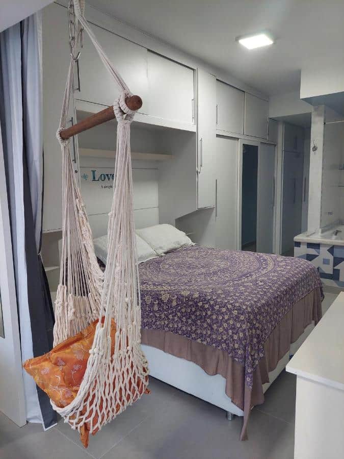 Quarto do Natureza na Barra da Tijuca com cama de casal do lado esquerdo da imagem com guarda-roupa em volta. Representa airbnb na Barra da Tijuca.