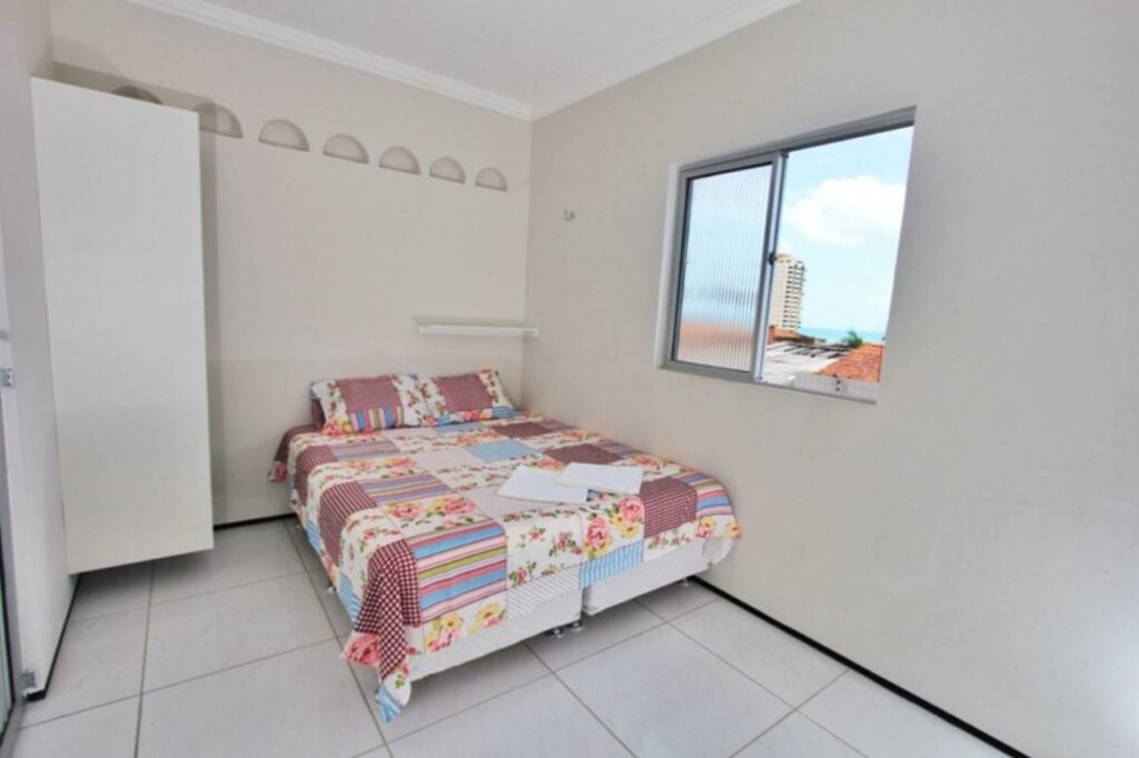 Quarto do airbnb Residencial Santa LuciaResidencial Santa Lucia. Uma cama de casal está ao lado de uma janela e encostado no canto da parede.