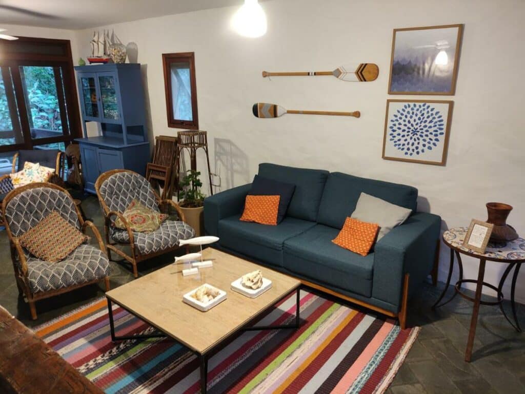 Sala de estar da Casa aconchegante em Guaeca – 8 pessoas com duas poltronas a frente e do lado esquerdo da imagem sofá e no centro uma mesa.