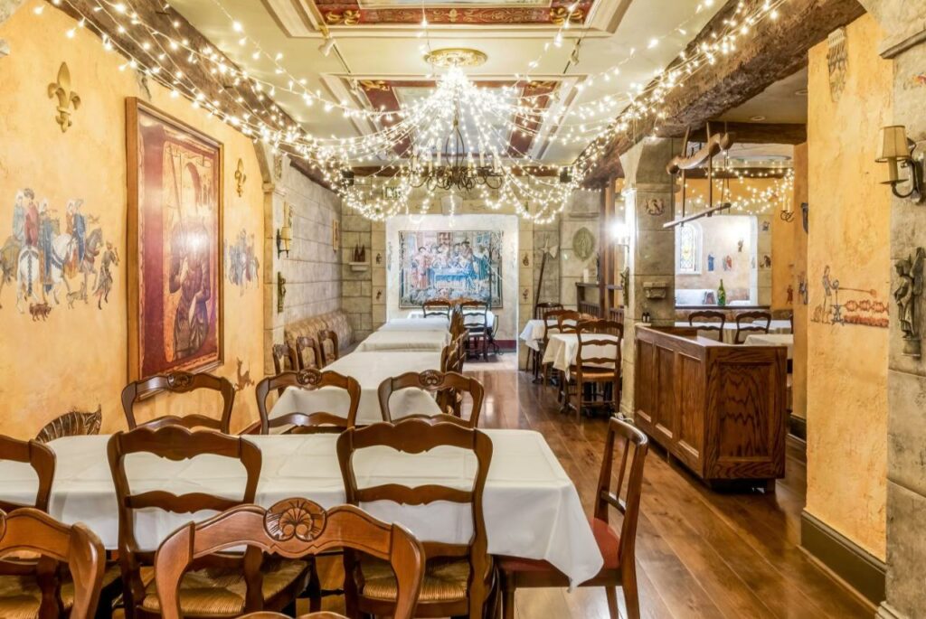 Sala de jantar do Cornell Hotel de France com cadeiras e mesas a frente.