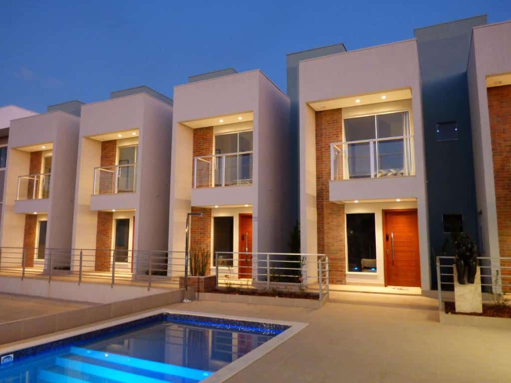 Fachada do VISTA DA SERRA CAPITOLIO com quatro apartamentos no estilo Townhouse com dois andares e na frente deles tem uma piscina. Imagem ilustrando post Airbnb em Capitólio.
