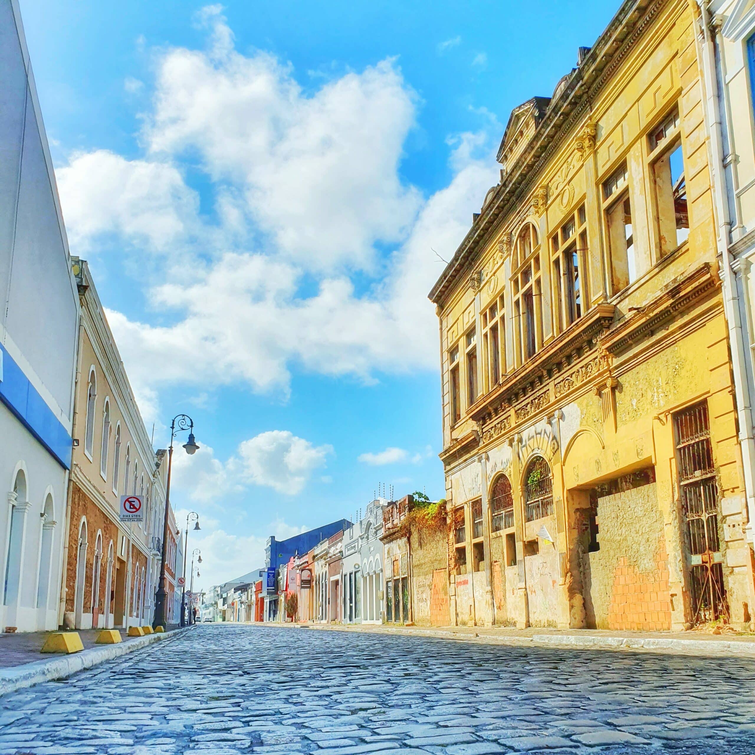 Rua de paralelepípedo com casarões históricos nos arredores. A imagem foi tirada de dia no bairro Jaraguá, uma das opções de o que fazer em Maceió
