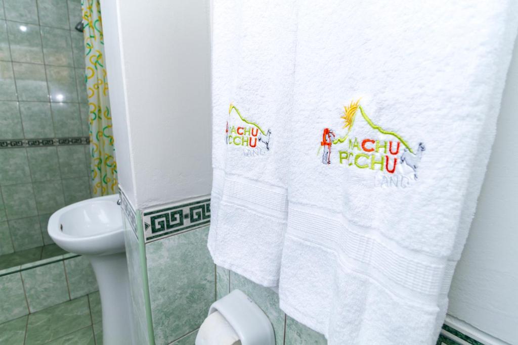 toalhas penduradas no banheiro do hotel machu picchu land, mostrando ao fundo a pia e o box da ducha no lado esquerda da imagem.