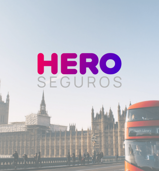 Cidade de Londres com o Palácio de Buckingham ao fundo, sob a imagem está o logo da marca Hero Seguros, para representar Hero Seguros