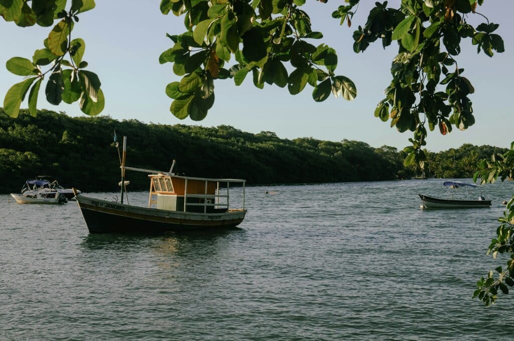 Barco navegando no rio durante o dia em Caraíva, Porto Seguro.