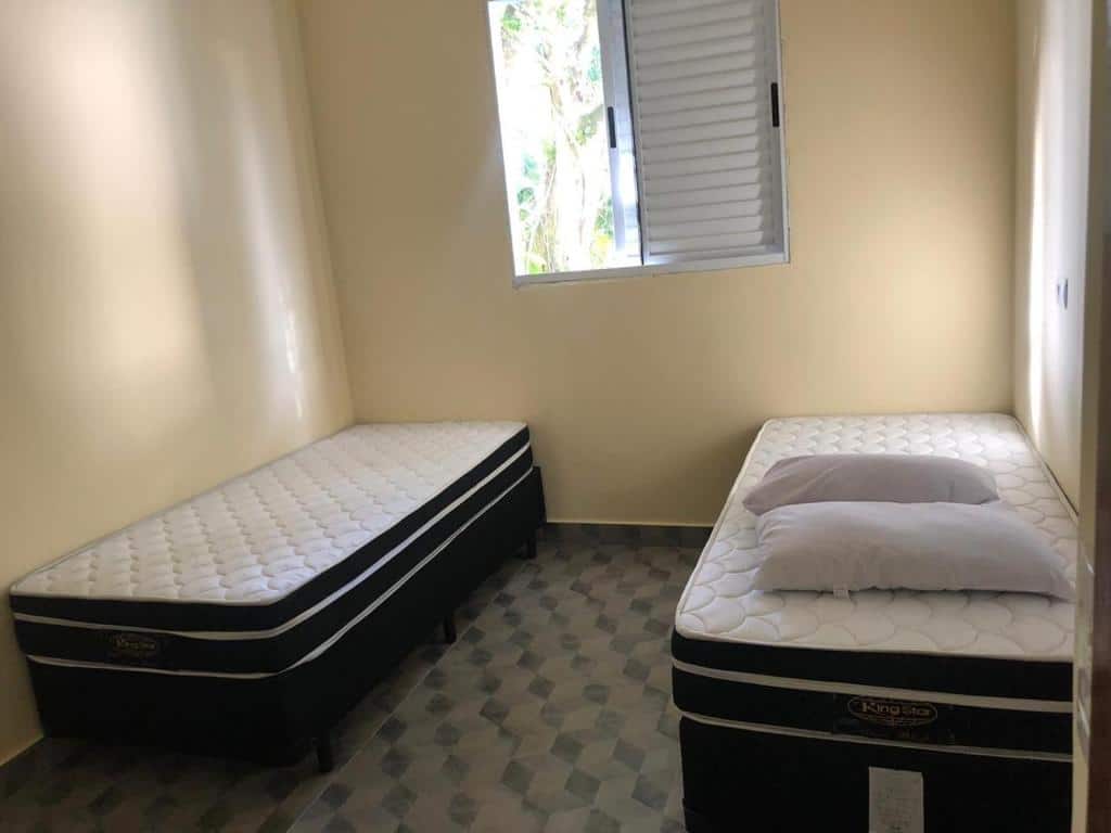 Foto do quarto no Residencial Marina Del Sol. Representa o post sobre airbnb em Paúba. Há duas camas de solteiro, uma ao lado da outra, e entre elas há uma janela.