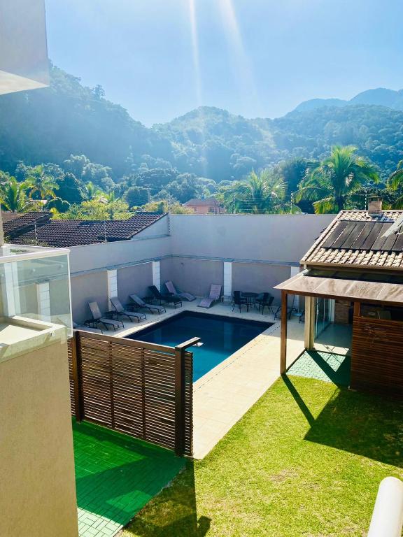 Casa na Linda Praia de Paúba! Vista do quintal da casa na janela do quarto. Há uma piscina e várias espreguiçadeiras.