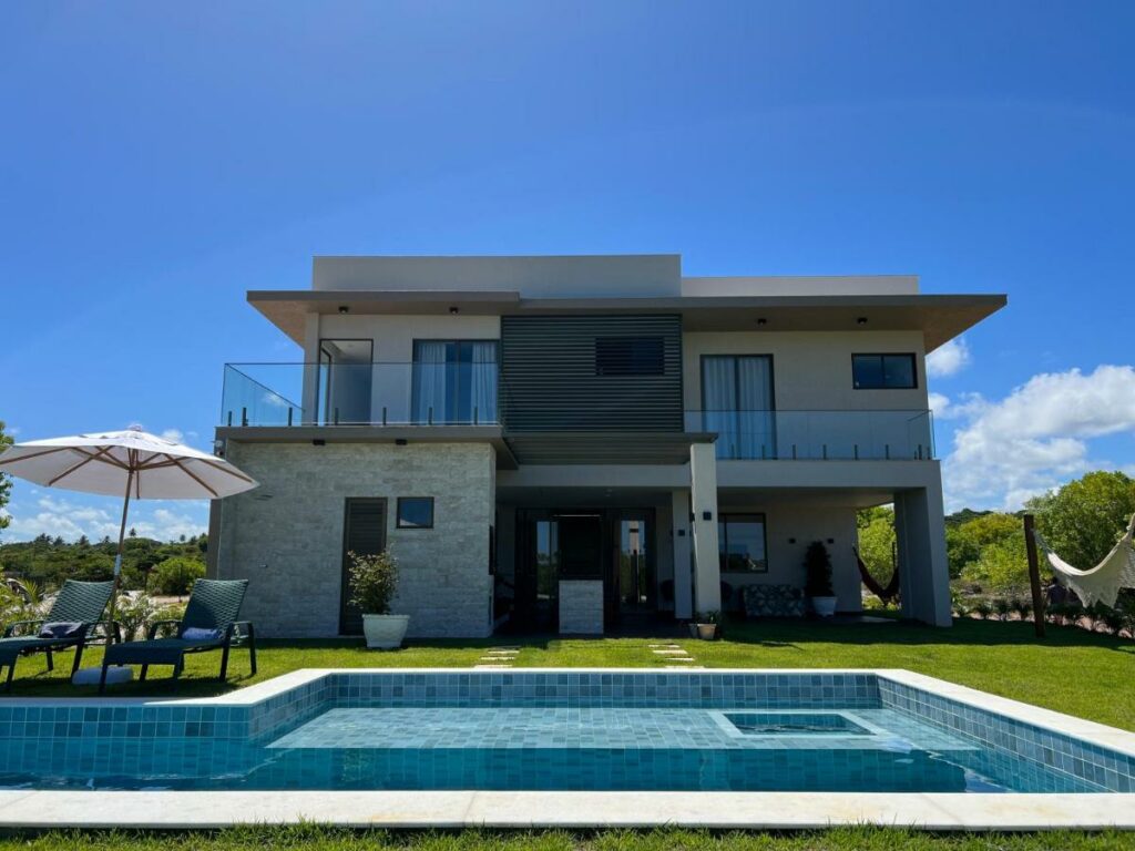 Frente da Casa da Laguna – Costa do Sauipe durante o dia com piscina a frente e ao fundo a estadia. Representa airbnb na Costa do Sauípe