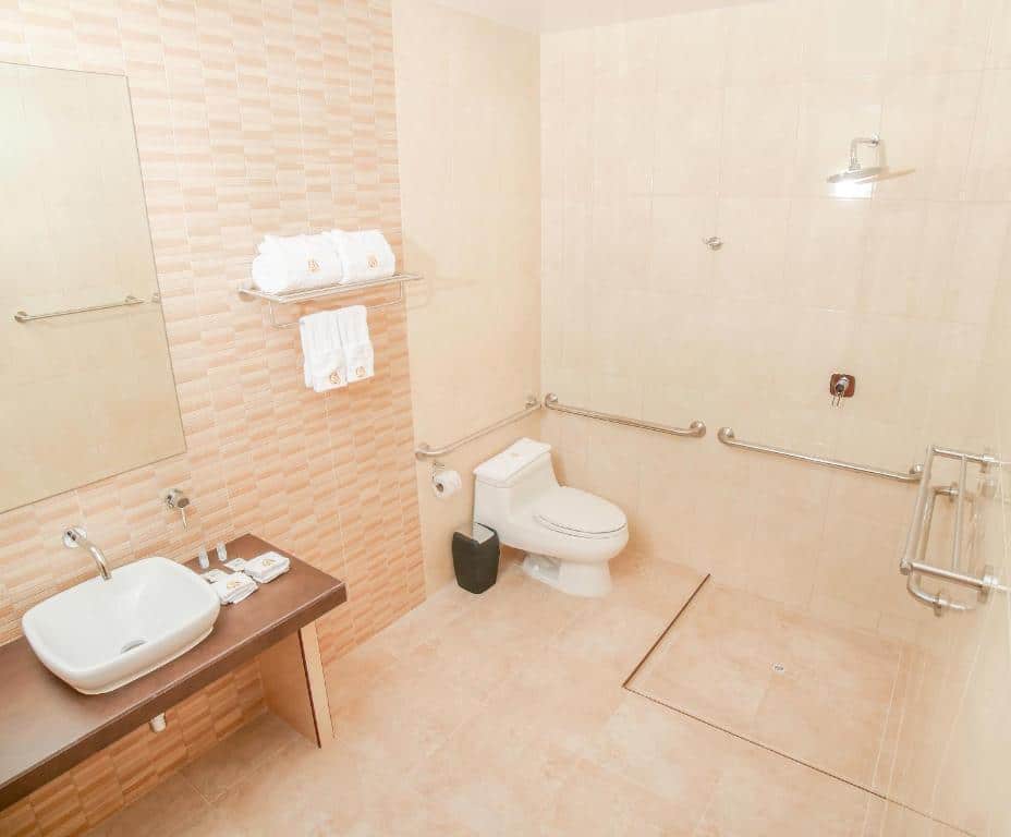 banheiro do Golden Sunrise com barras de apoio no vaso sanitário e na área do box de ducha.