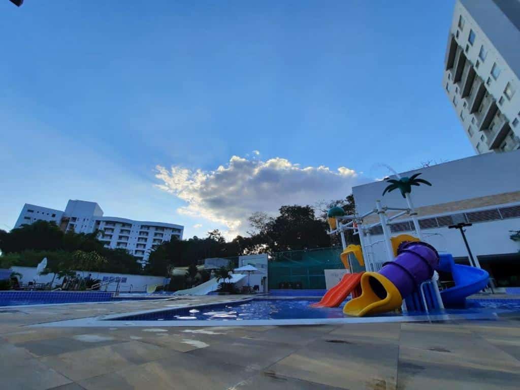Área externa do Park Veredas. No meio uma piscina com brinquedo infantil, de cada lado um hotel no fundo.