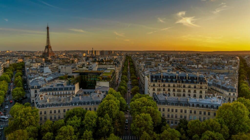 Visão aérea de Paris na França, onde é possível avistar a Torre Eiffel, prédios históricos e muitas árvores