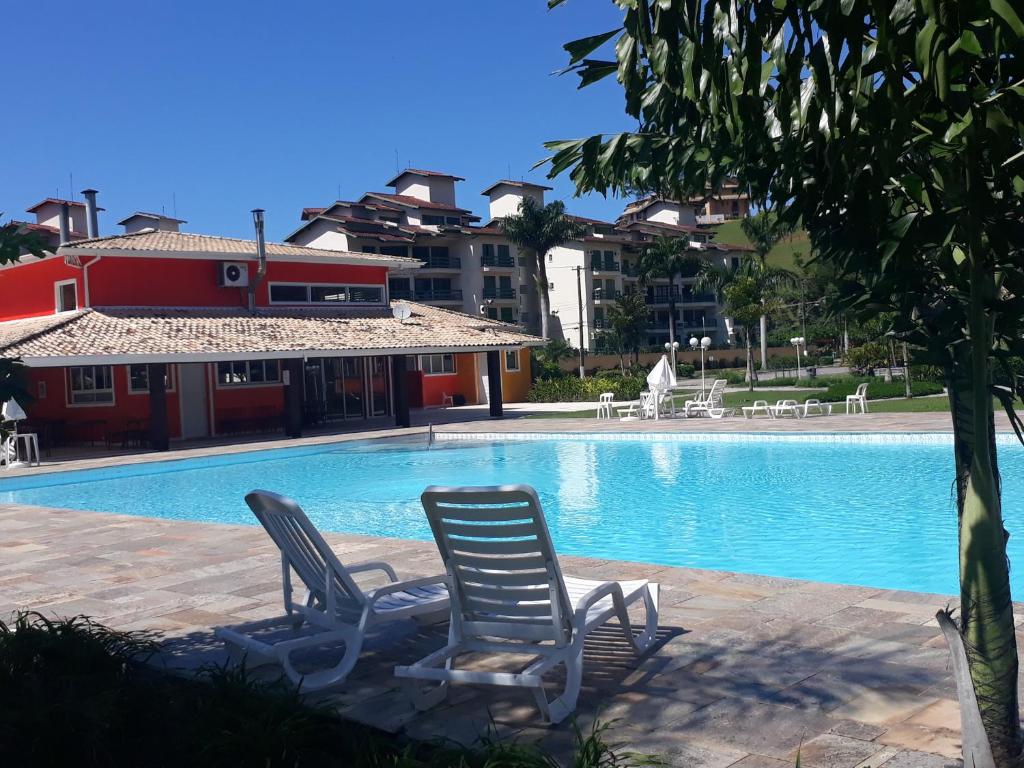 Piscina ao ar livre do Apartamento a 50m da areia – Praia da Tabatinga durante o dia com duas cadeiras a frente e ao fundo a piscina.