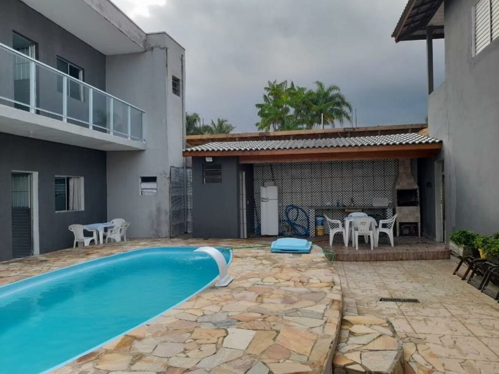 Área de lazer da Casa com piscina 20 metros próximo da praia durante o dia com piscina do lado esquerdo da imagem e do lado direito o pátio.