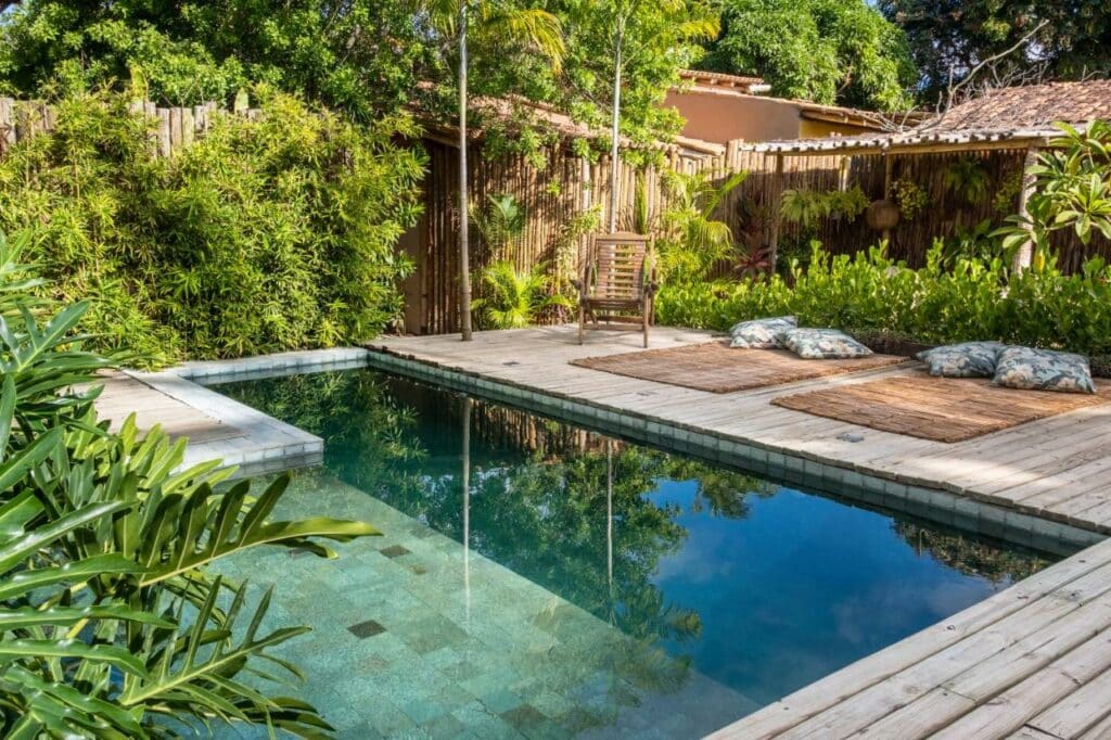 Piscina ao ar livre da Casa das Conchas Caraiva durante o dia com piscina do lado esquerdo da imagem.