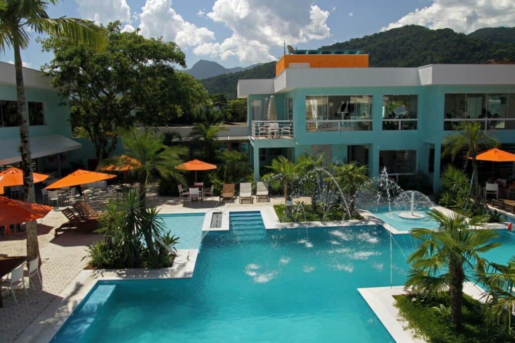 Vista de cima do Hotel Port Louis durante o dia com piscina ao centro a frente e ao fundo a estadia. Representa airbnb na praia de Tabatinga