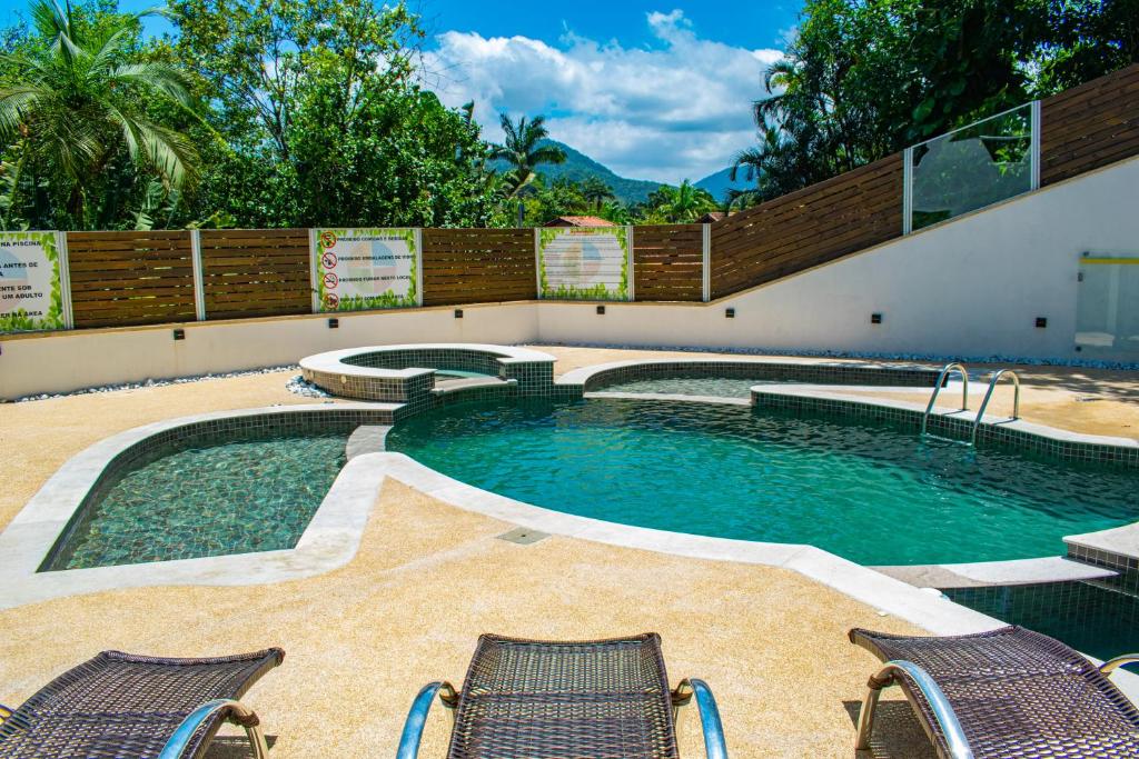 Imagem da piscina ao ar livre da Pousada do Tenório durante o dia com três cadeiras a frente com vista para a piscina. Representa airbnb na praia do Tenório.