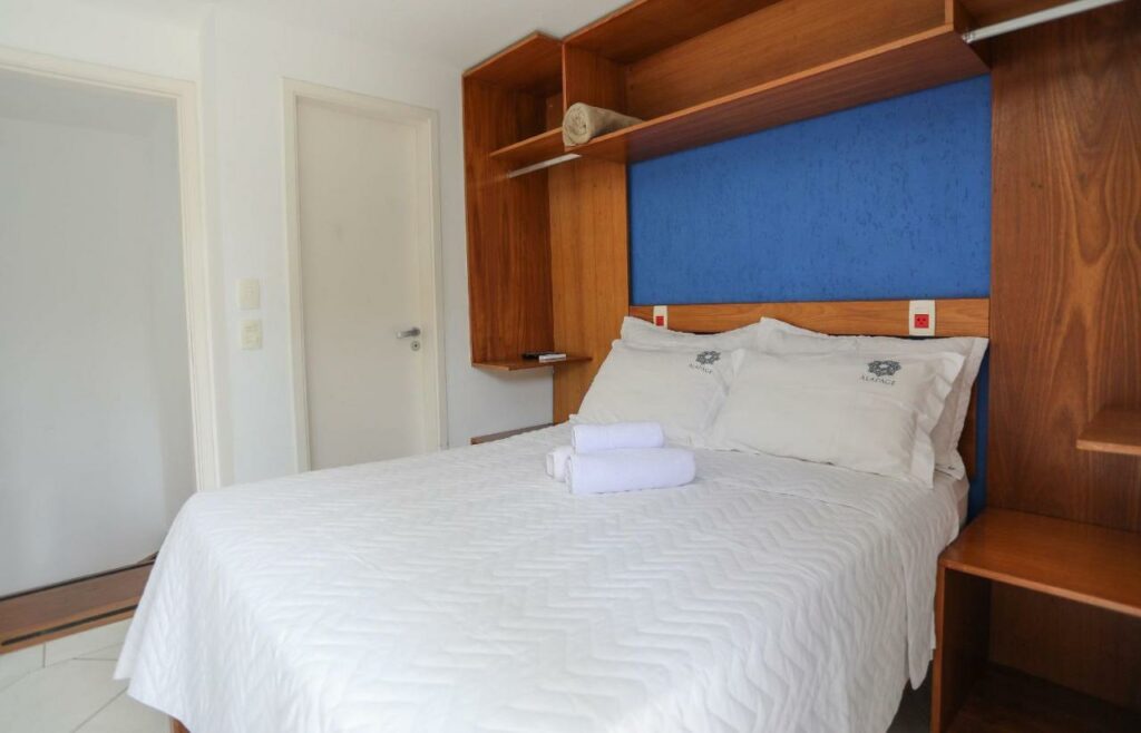 Quarto do Alapage Toque Toque com uma cama de casal do lado direito com uma cômoda em cada lado. Representa airbnb na praia de Santiago.