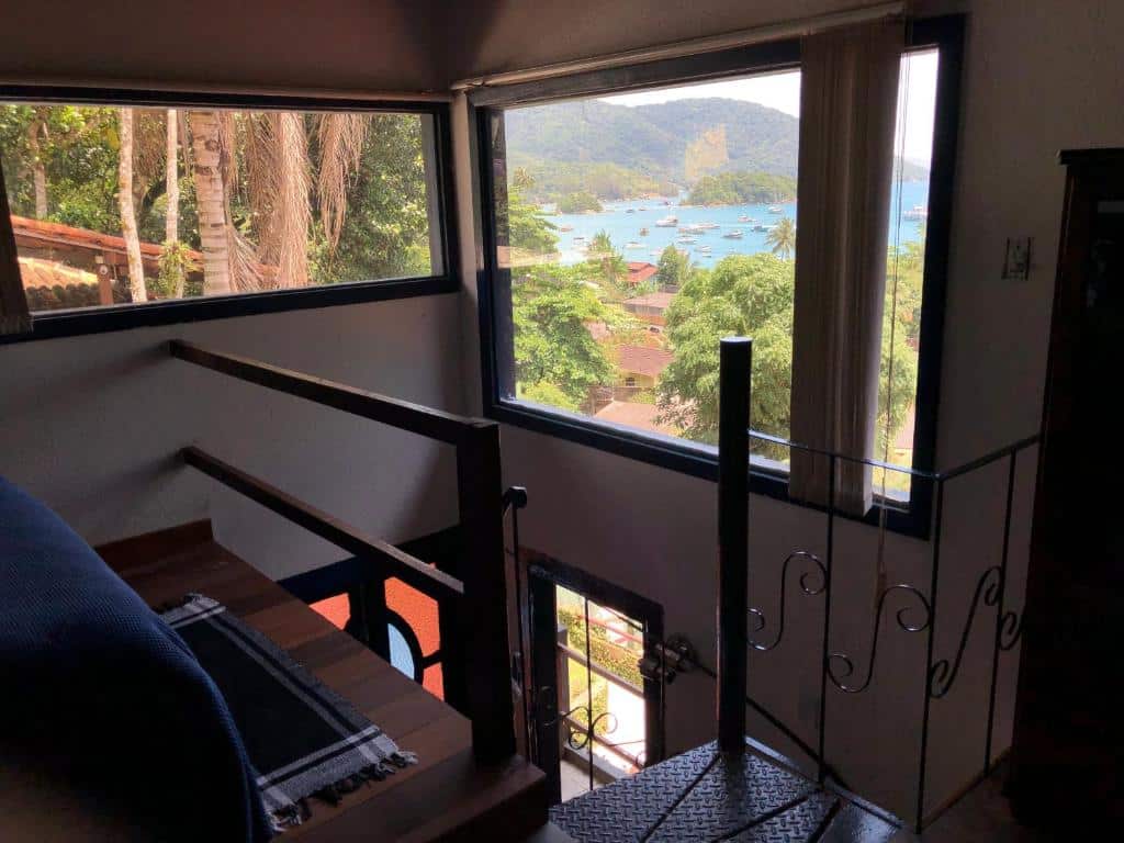 Quarto do airbnb Bergamota. No canto esquerdo é possível ver parte da cama e no lado direito há uma escada que desce para o primeiro andar. Imagem para ilustrar o post airbnb em Ilha Grande.