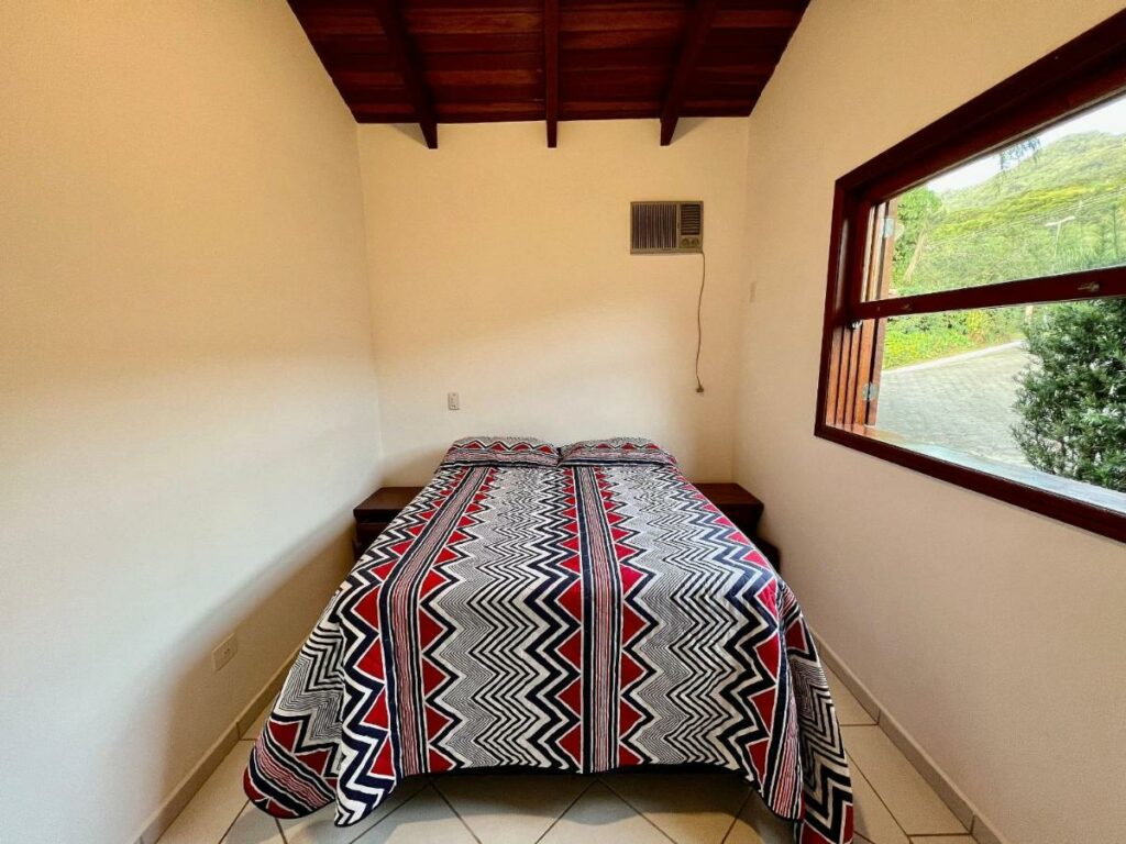 Quarto da Casa com piscina privativa no Paúba um Vilarejo  com cama de casal no centro do quarto e uma cômoda em cada lado da cama. Representa airbnb na praia de Santiago.
