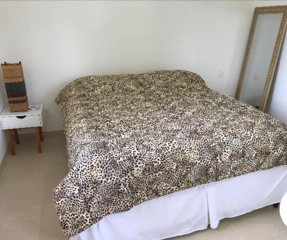 Quarto da Casa Complexo Costa do Sauípe com cama de casal a frente e do lado esquerdo da cama uma cômoda. Representa airbnb na Costa do Sauípe