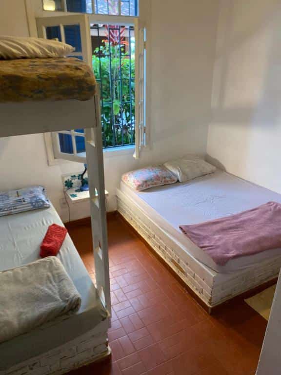 Quarto familiar da Casa na quadra da Praia do Tenório com uma cama de casal do lado direito da imagem do lado esquerdo uma cama beliche. Representa airbnb na praia do Tenório.