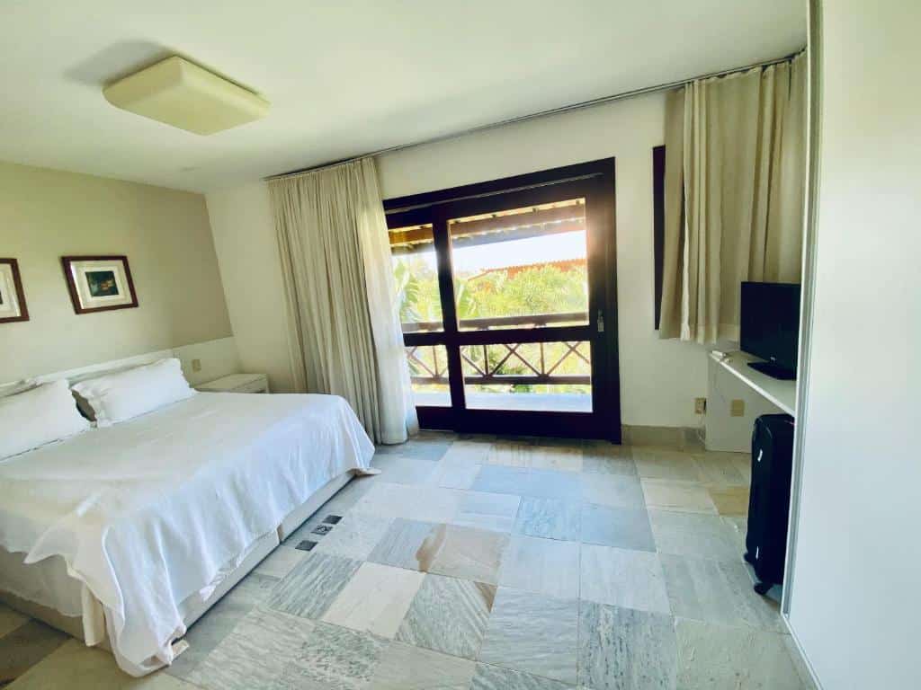 Quarto do Costa do Sauipe Casa dentro do complexo hoteleiro com cama de casal do lado esquerdo da imagem, do lado esquerdo da cama uma cômoda e em frente a cama uma cômoda com TV. Representa airbnb na Costa do Sauípe