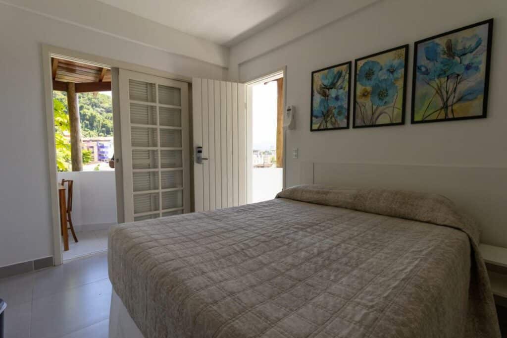 Quarto do Hotel Coquille com cama de casal do lado direito da imagem. Representa airbnb na praia da Lagoinha.