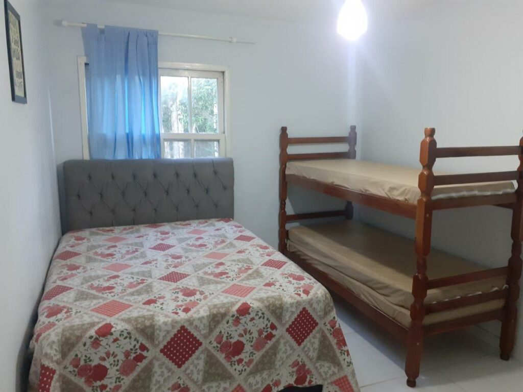 Quarto familiar do Lindo Apto Praia da Tabatinga com cama de casal do lado esquerdo da imagem e do lado direito uma cama beliche. Representa airbnb na praia de Tabatinga.
