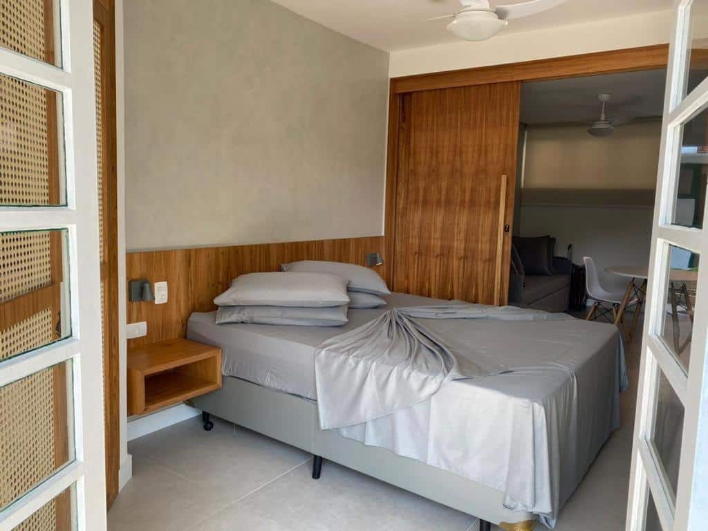 Foto do quarto no Residencial Marina Del Sol. Representa o post sobre airbnb em Paúba. O ambiente é moderno e bem decorado. Há uma cama box de casal no centro, do lado direito dela há uma porta que a separa da sala e cozinha, e na esquerda há uma porta para a varanda.
