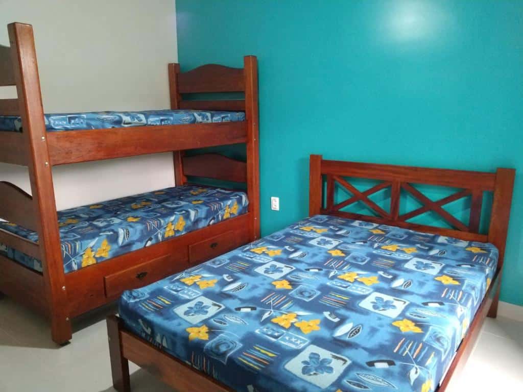 Quarto em família do Praialar Apartamentos Ubatuba com uma cama de casal do lado direito e do lado esquerdo uma beliche. Representa airbnb na praia de Tabatinga