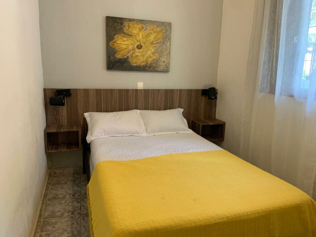 Quarto do Sean bora praia com cama de casal no centro do quarto. Representa airbnb na praia da Juréia.