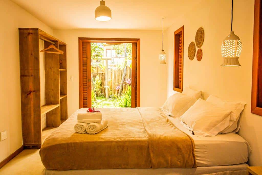 Quarto da Vila Nativa Caraíva com cama de casal do lado direito da imagem, do lado direito da cama um armário do lado esquerdo.