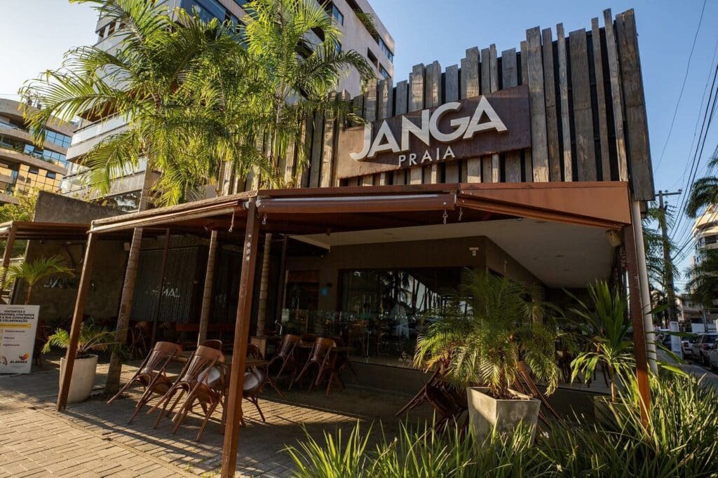 Frente do restaurante Janga Praia, com flores e paredes de bambu. Acima há uma placa escrito "Janga Praia". Representa um dos restaurantes em Maceió