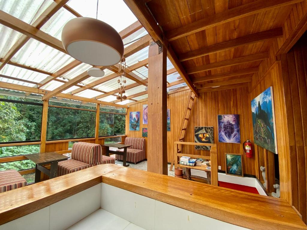 bar do místico eco B&B com teto solar e móveis de madeira. No lado esquerdo é possível enxergar a vegetação verde dos andes