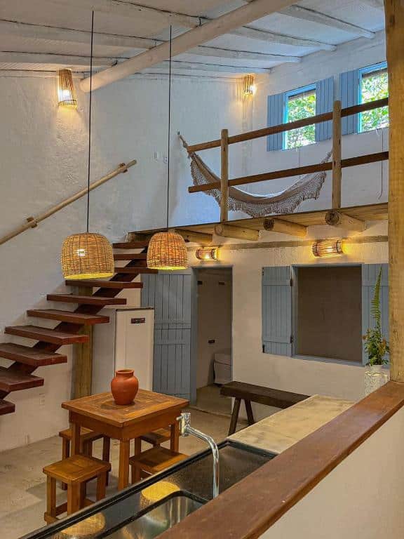 Cozinha da Casinha do Rio com pia do lado direito, uma mesa quadrada pequena de quatro cadeiras.