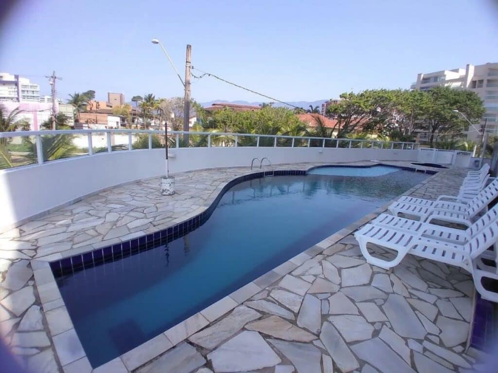 Piscina dos terraços do maitinga cercada por espreguiçadeiras e árvores, para representar airbnb em Bertioga.