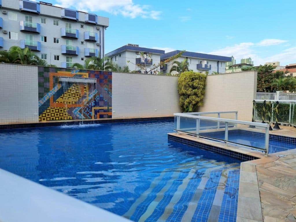 Uma piscina no meio, com uma divisória para piscina infantil, no meio uma cascata no Apartamento Avenida Wilson.