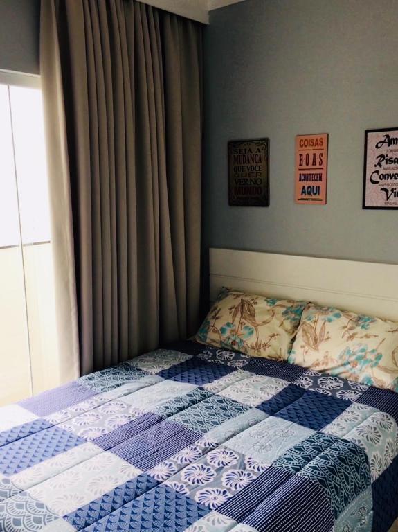 Imagem do quarto do Boulevard Center. Há uma cama de casal no centro, e na sua esquerda há uma janela. Atrás da cama há uma parede com quadros.