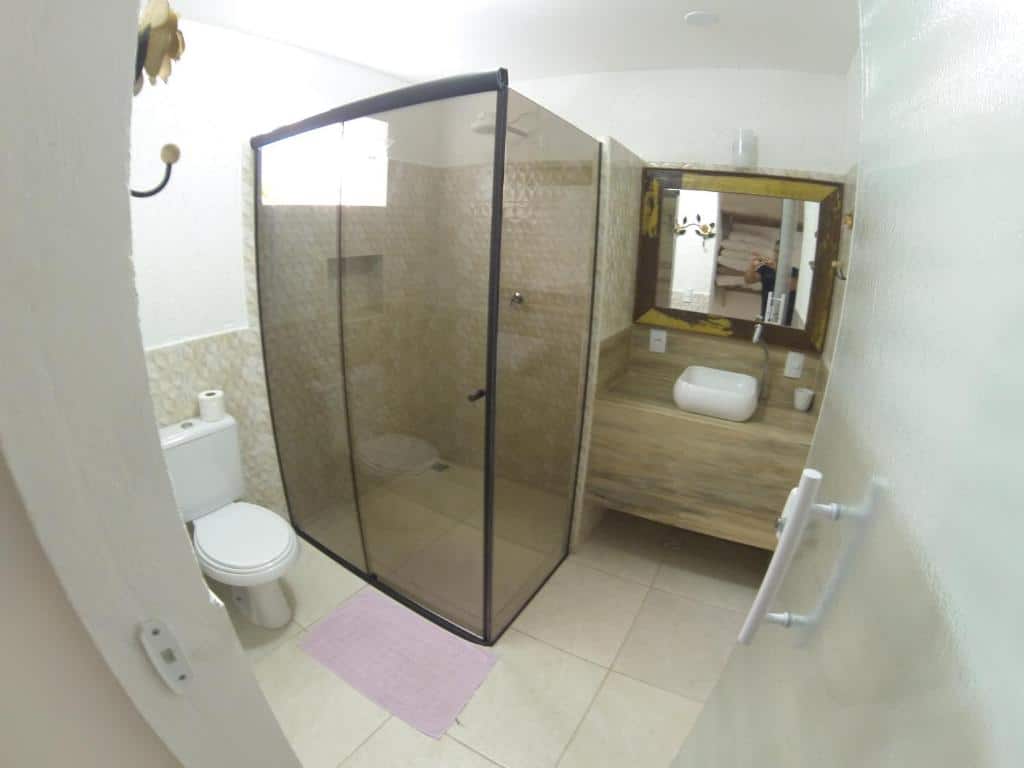 Banheiro da Casa do Monge Apartments. A privada está ao lado do box. Na parede em frente à porta, de onde a foto foi tirada, está a pia com espelho.