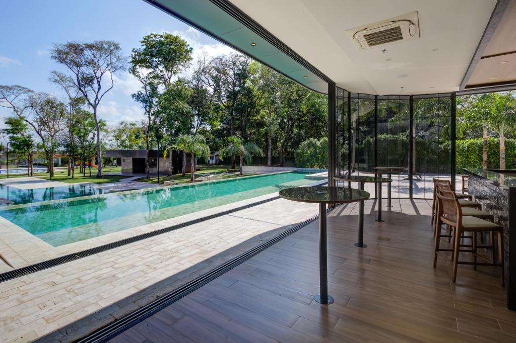 Foto do DoubleTree by Hilton, mostrando a área da piscina, que está à esquerda, e um quiosque à direita. Debaixo da parte coberta do quiosque á um balcão com várias cadeiras.