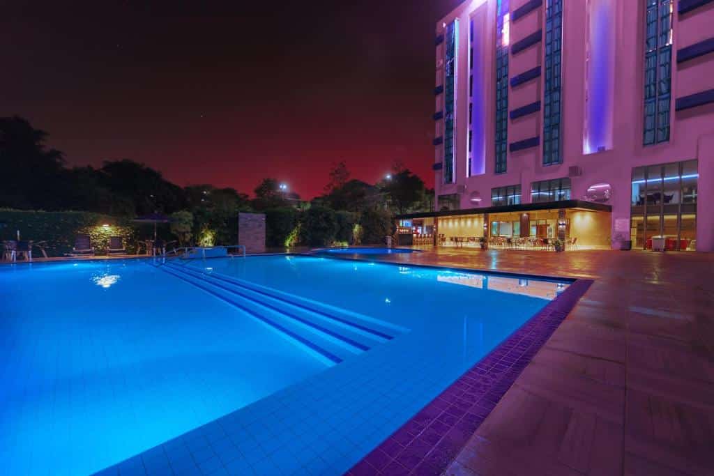 Foto do Falls Galli Hotel tirada à noite mostrando a piscina na esquerda e o hotel na direita.