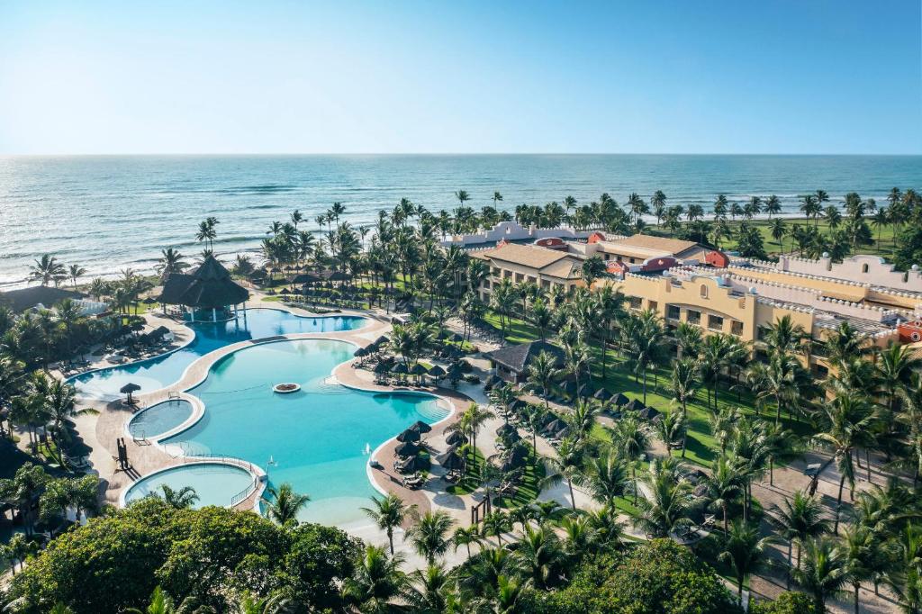 Vista aérea do Iberostar Bahia - All Inclusive. Vemos as piscinas, os coqueiros, o hotel e o mar ao fundo.